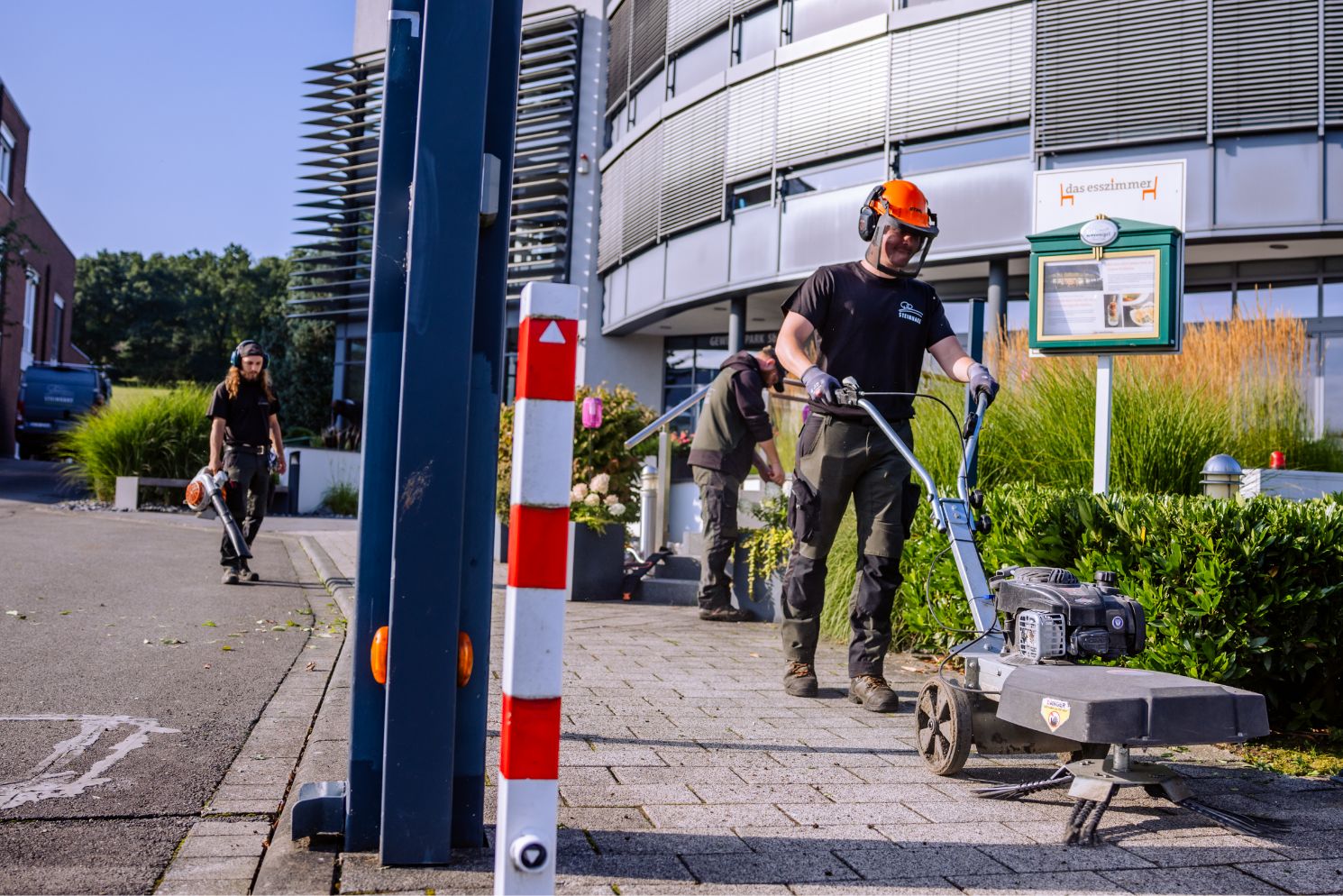 Gartenpflege-Team, das einen großen Parkplatz reinigt.