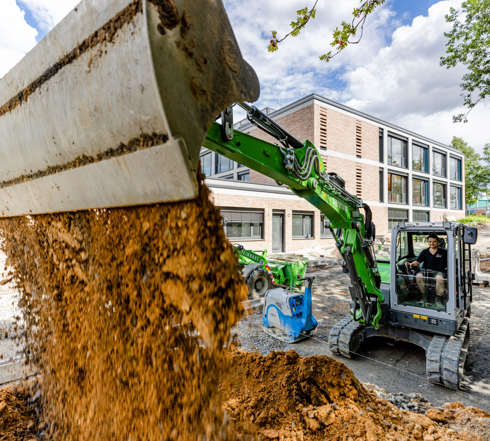 Steinhake beim begradigen eines Schulhofs